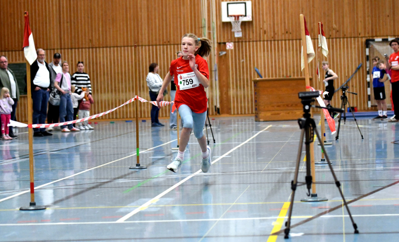 Wer ist der(die) Schnellste: Beim fliegenden Sprint &uuml;ber 15 Meter durch die Lichtschranken ging es f&uuml;r die M&auml;dchen und Jungen um hundertstel Sekunden. Foto: Bottin|Die Allerj&uuml;ngsten mussten beim 30-Meter-Sprint schon mal an die Hand genommen werden - wie hier von LAZ-Trainerin Jana Klee. Foto: Bottin|Werfen durch hochgeh&auml;ngte Reifen war eine von mehreren Disziplinen beim Indoormeeting des LAZ Soest. Foto: Bottin|Sophie Bornemann (links) und Charlotte Biegel beim Sprint &uuml;ber 30-Meter-H&uuml;rden. Foto: Bottin|Der Sprint &uuml;ber kindgerechte H&uuml;rden geh&ouml;rt seit Jahren zum festen Bestandteil beim Indoormeeting des LAZ Soest. Foto: Bottin|Der Hochsprung mit Hilfe des Sprungbretts ist f&uuml;r den Nachwuchs eine der Lieblingsdisziplinen beim Indoormeeting des LAZ Soest. Foto: Bottin||||